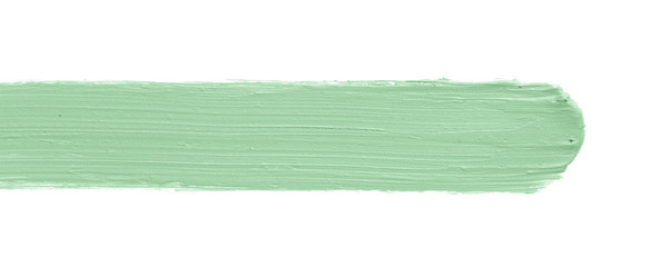 Color corrector stroke isolated on white background. Green color correcting concealer cream smudge smear swatch sample. Makeup base creamy texture