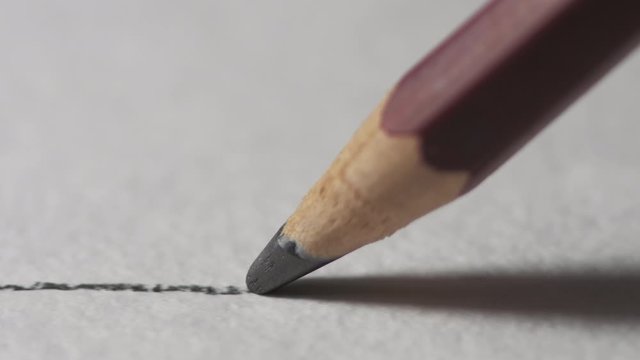 Artists hands drawing wooden pencil writes line on paper. Education handwriting exercise with red pencil. Dynamic closeup shot filmed in 4k UHD 2160p