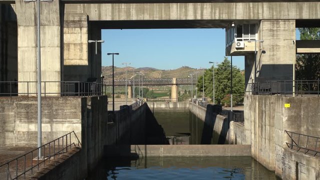 Closer view of Barragem do Pocinho dam as a river cruise boat on the Douro starts to approach the closed lock gates