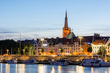 Obraz premium Szczecin City skyline reflected in the Odra River at dusk, Poland.