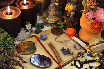 Still life with magic objects, open diary, gemstone, crystal ball and burning candle on witch table. © samiramay