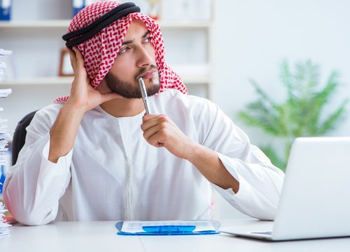 Arab businessman working in the office doing paperwork with a pi