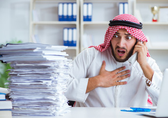 Arab businessman working in the office doing paperwork with a pi