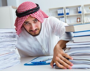 Arab businessman working in the office doing paperwork with a pi