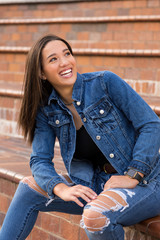 Mixed raced teenage girl sitting on brick steps