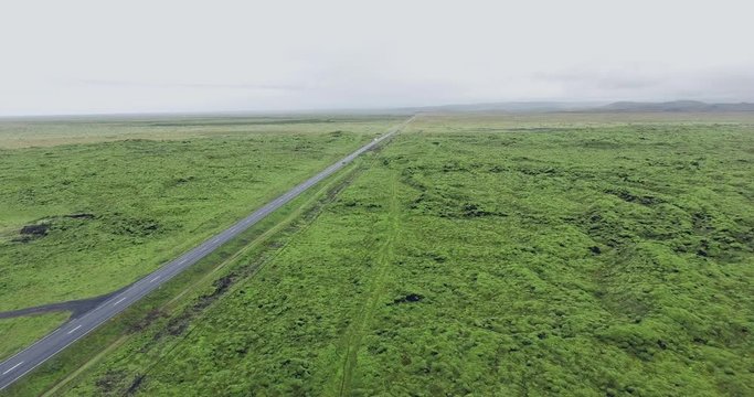 Aerial view car on the road throught the green moss in Eldhraun lava field covered green moss in Iceland