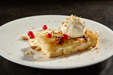 Apple pie slice with ice cream scoop side view