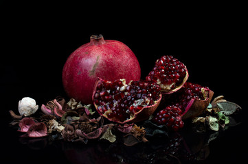 ripe pomegranate rustic style on black isolated background still life