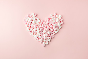 Pink marshmallow in heart shape stacked on pink table with copy space. Sweet candy for love theme...