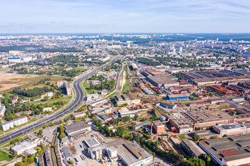 Fototapeta na wymiar aerial panoramic view of city industrial area with lots of industrial buildings, plants and storehouses