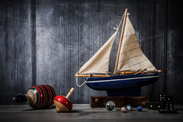 Vintage toy still life with boat, tops, marbles and dominos