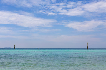 Obraz premium Transperent sea water background and blue sky with white clouds.