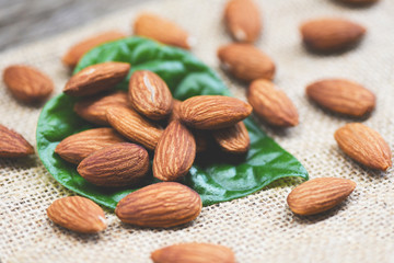 Almonds on green leaf / Close up almond nuts natural protein food and for snack on sack background