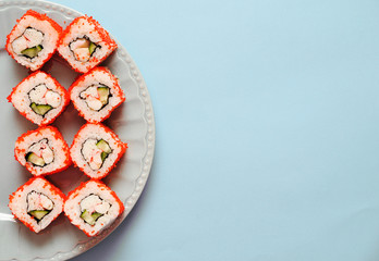 Japanese rolls on grey plate on blue background.
