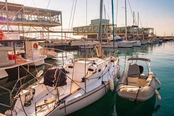 Fototapeta premium Cyprus. Limassol. Coast of the Mediterranean sea. Boats and yachts at the pier. Pavilions for relaxation with sea views. Promenade Of Molos. Port pier. Cruise port.