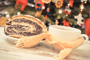 Vintage photo, Traditional polish poppy seeds cake, coffee or tea in cup and christmas tree with decoration