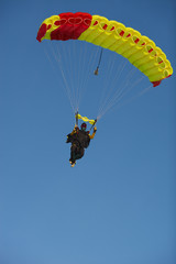 Skydiver under the canopy of the parachute against a blue sky. Parachute jumps. Skydiving.