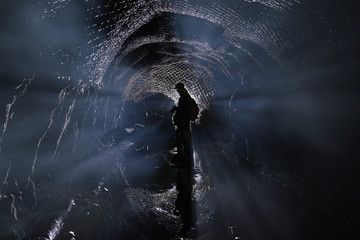 Silhouette of a man in an abandoned underground tunnel, an abstract image in a backlight. Abandoned...