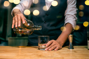bartender pouring drink in a bar