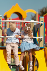 Girl and boy play in the playground, friends communicate in kindergarten