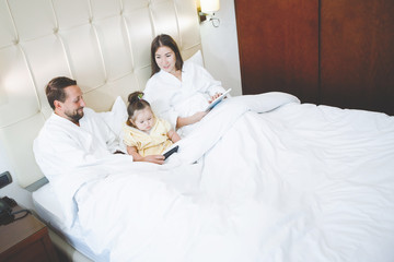 Obraz premium Mom, dad and daughter in bed.