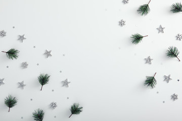 Corner with pine branch, silver snowflake and star over white