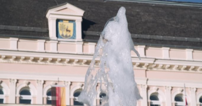 Close up slow motion shot, fountain with refocus to old castle, mansion, royal palace in Europe (Austria), 4K.