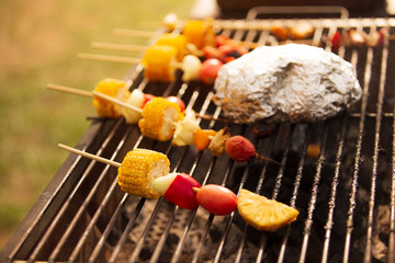 Skewers of delicious corn onions, red peppers and colorful tomatoes for a healthy vegetarian meal, complete with barbecue on a fire-cut stove.soft focus.shallow focus effect.