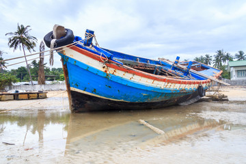 Fototapeta na wymiar Wreck of boat moored on beach
