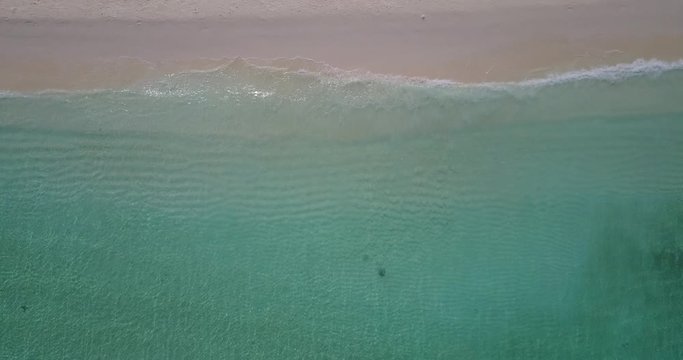 Sea texture of tropical seashore seen from top with calm clear turquoise seawater washing pink sand of exotic beach in Bermuda, copy space