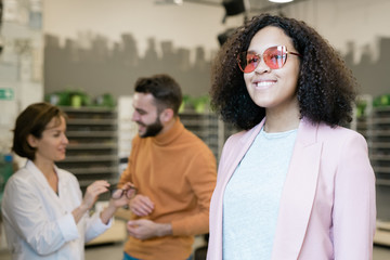 Young cheerful woman with toothy smile wearing new eyeglasses