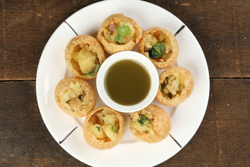 Tadeonal subcontinental street snack food chickpeas potato pani puri fuska with tamarind sauce © oqba