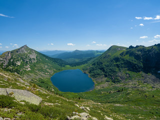 View from a high point on a mountain lake and peaks in the Ergaki Nature Park. Sunny day in the...