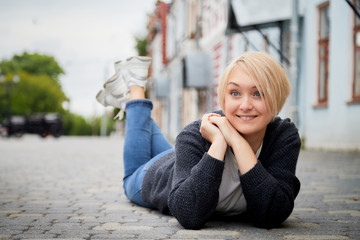 Blonde funny pretty girl in the Central part of the ancient city. Walk in downtown. Portrait of a girl on the street