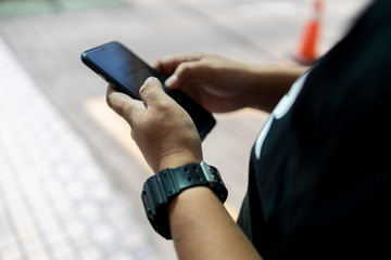 Hand holding phones at road side
