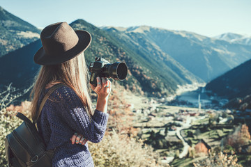 Stylish trendy hipster woman traveler photographer in a felt hat with dslr camera taking pictures of the mountains and uzungol lake in Trabzon during Turkey travel - obrazy, fototapety, plakaty