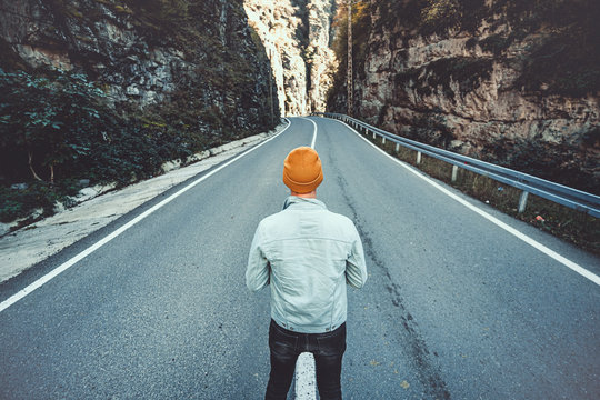 One Lonely Man Stands On The Road Among The Rocks In Mountains. Go Forward On Your Way To Goals And Dreams