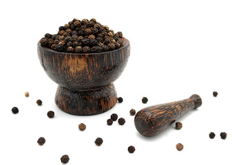 closeup the black pepper in Wooden mortar on white background , selective focus. Herbal Medicines.