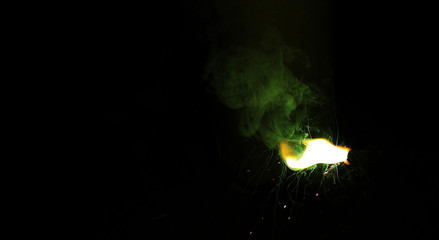 green smoke sparkler on sparkling with dark background with green color smoke on the deepavali / dewali celebration