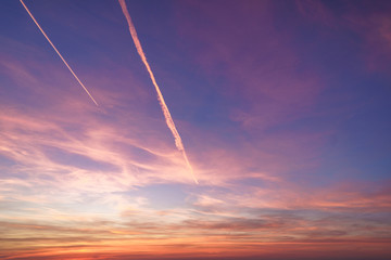 Fototapeta na wymiar Bewitching gradient sky with plane traces after sunset