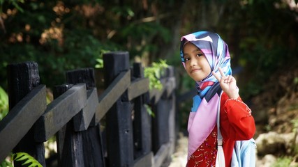 Portrait of young girl wearing traditional dress 'baju kurung' with hijab. Selected focus. Image...