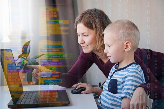 Young programmer writing code on a computer together with his mom or teacher. Programming lessons for kids.