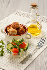 Fried meat cutlets in ceramic soup bowl and bottle with sunflower oil