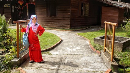Portrait of young girl wearing traditional dress 'baju kurung' with hijab. Selected focus. Image contain certain grain or noise and soft focus when view at full resolution.