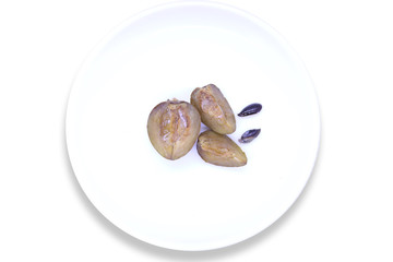 Sapota fruit cut into pieces and seeds in plate