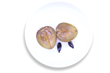 Sapota fruit cut into pieces and seeds in plate