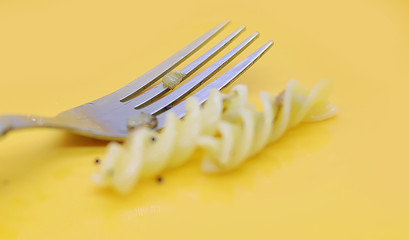 italian pasta with fork on yellow background