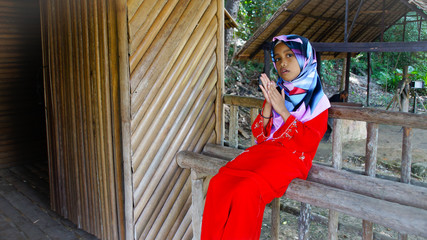 Portrait of young girl wearing traditional dress 'baju kurung' with hijab. Selected focus. Image contain certain grain or noise and soft focus when view at full resolution.