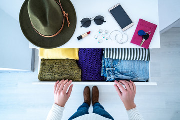 Woman choosing outfit from drawer dresser with stylish casual trendy clothes, home stuff and female...