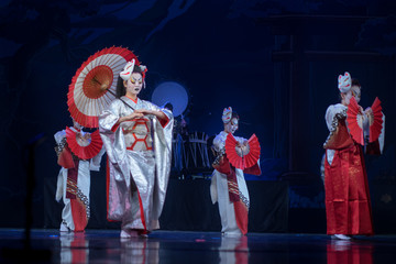 Traditional Japanese performance. Actresses in traditional white and red kimono and fox masks...